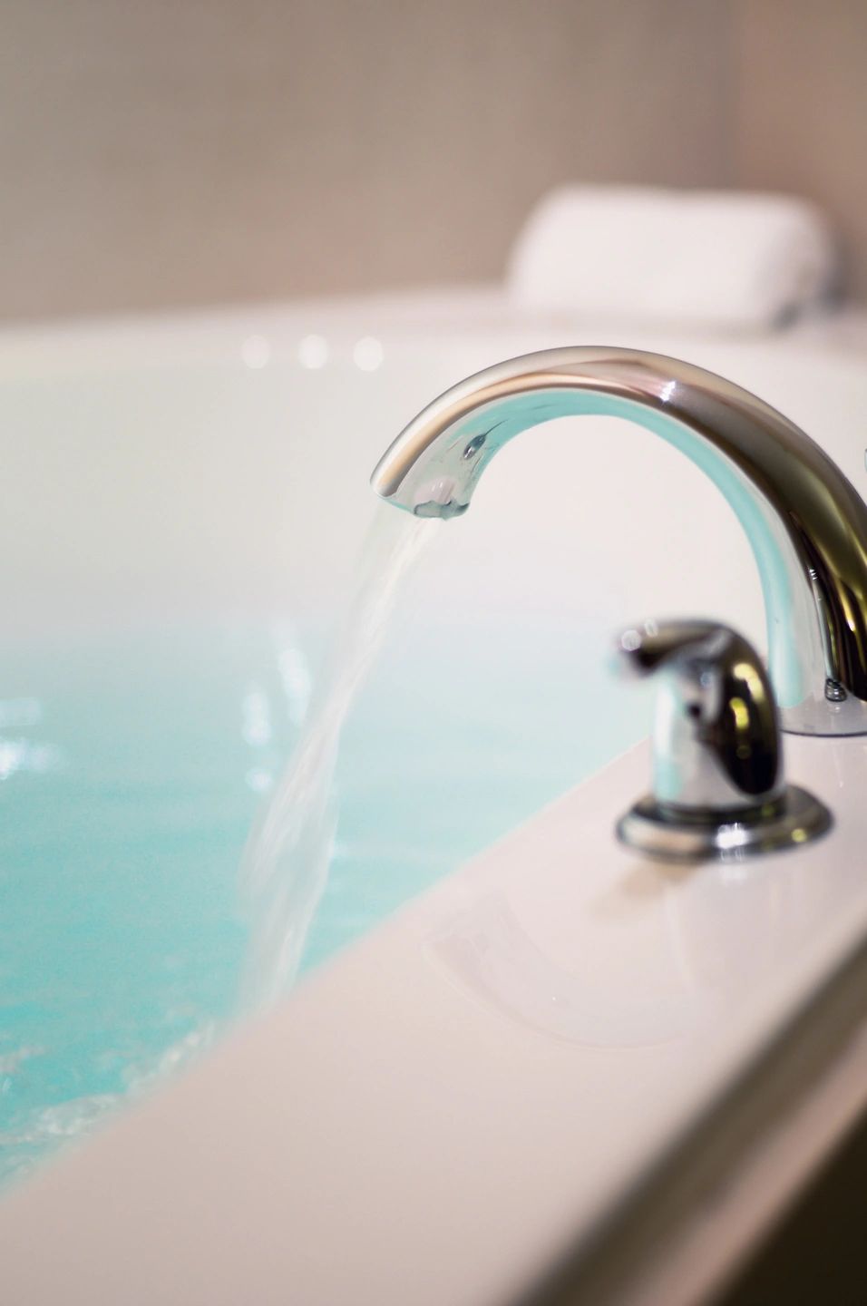 Water pouring from a chrome spout into a bathtub